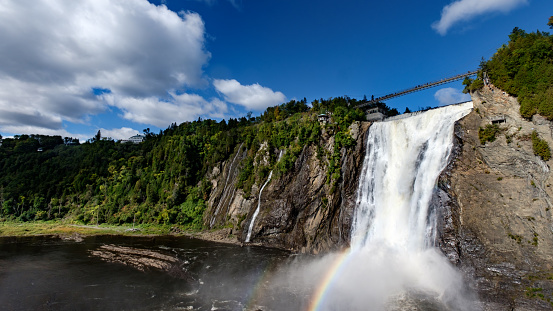 A wide view of Montmorency Falls, fantastic blue skies, clouds & rainbow! Quebec, Canada.