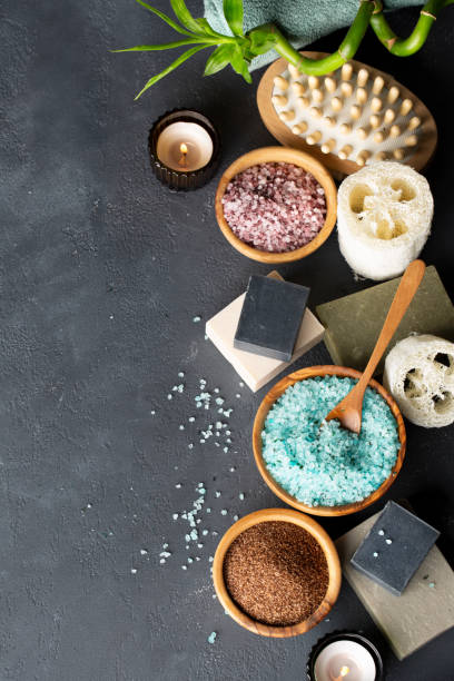 Spa. Natural cosmetics for the body and face. Blue sea salt with seaweed, soaps of herbs and dead sea mud, loofah washcloth, massage brush, ground coffee scrub on a dark table. Top view. Copy space. spa. cosméticos naturales para el cuerpo y la cara. sal marina azul con algas, jabones de hierbas y barro marino muerto, paño de loofah, cepillo de masaje, exfoliación de café molido sobre una mesa oscura. vista superior. copiar espacio.