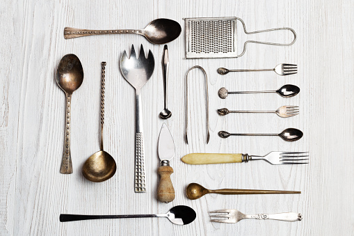 Kitchen utensils background - spoons, forks, cheese knife, grater, tongs