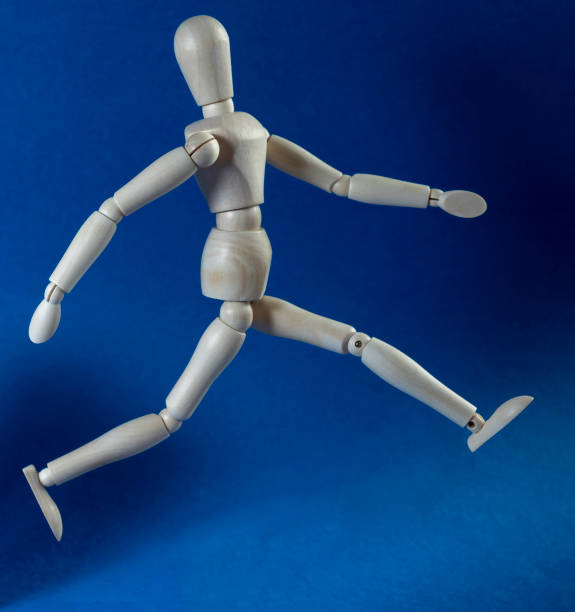 istock wooden man runs on a blue background 1218384768