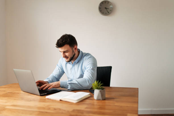 istock Attractive male office worker is using a laptop 1218385943