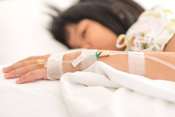 アジアの子供の患者の子供の女の子の入院患者悲しい病院のベッドの上のためのiv注入ドロップを見てください。がん化学療法ケモ医療の概念 - 3894 ストックフォトと画像