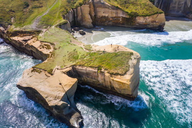 Tunnel Beach, Dunedin, New Zealand, aerial view Famous Tunnel beach in New Zealand, DUNEDIN, NEW ZEALAND Popular tourist attraction in Dunedin, South island of New Zealand, amazing coast line from above with a drone, Cliff formations at Tunnel Beach dunedin new zealand stock pictures, royalty-free photos & images