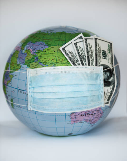 istock Globe with money covered with respiratory mask - Covid 19 1218389690