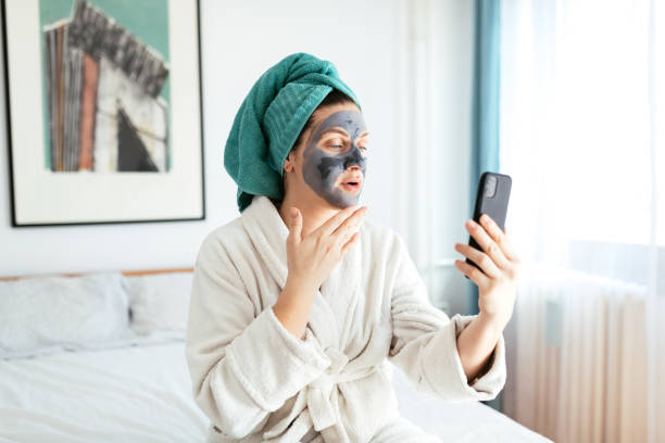 istock Woman wearing beauty mask and vlogging on internet 1218391301