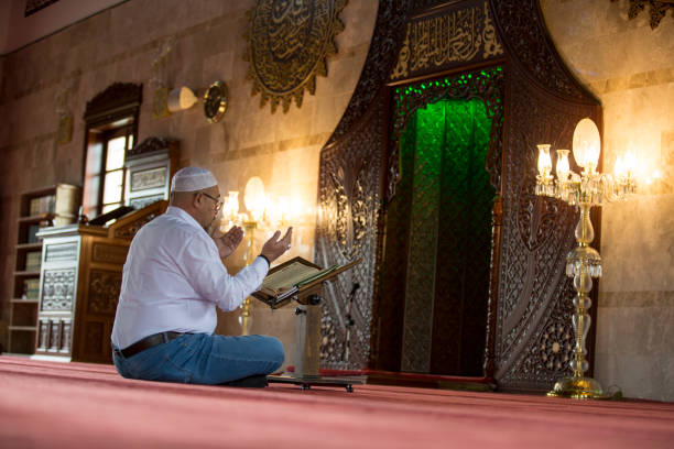 istock Muslim man reading Koran in mosque 1218391424