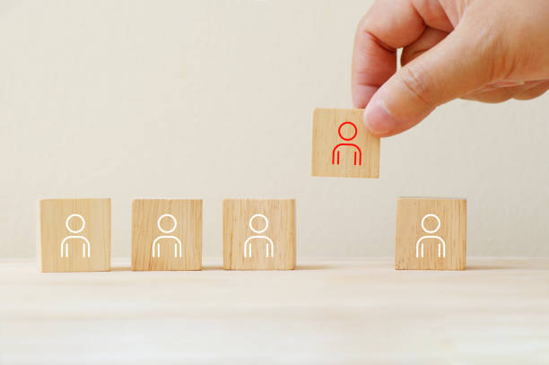 istock Person icon on wooden cube with hand pick different from them. 1218393255