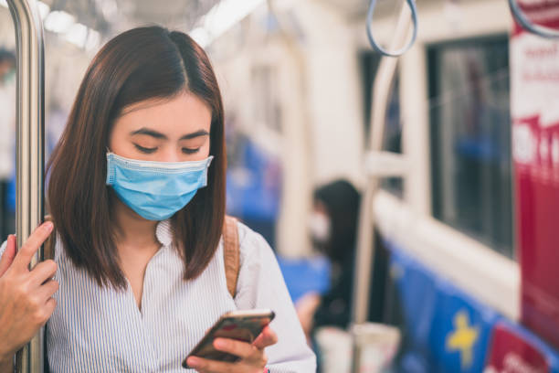 istock Young asian woman wearing protective face mask using smartphone in underground train due to the polluted air or pm 2.5 and Coronavirus or COVID-19 outbreak situation in all of landmass in the world. 1218395188