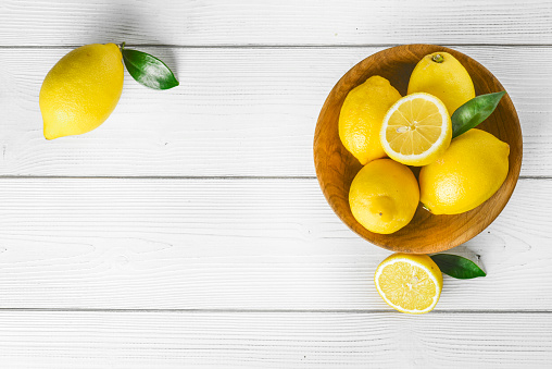 Lemon top view on old withe vintage table. Group of lemons concept with copy space.