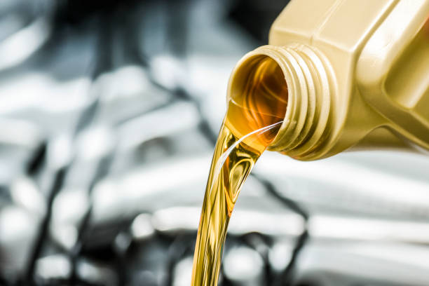 la main de femme verse l’huile de moteur au moteur de voiture. - lubrication photos et images de collection