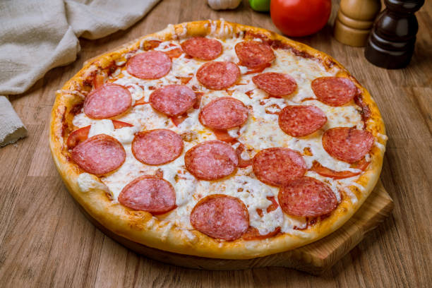 istock Pepperoni pizza on the board on wooden table 1218398741