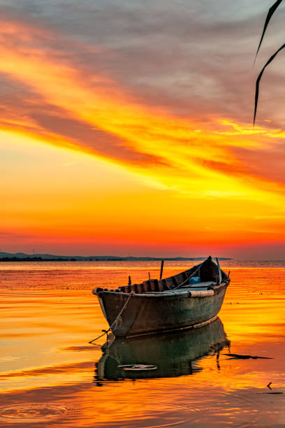 istock Beautiful sunrise with a boat on the lake 1218400150