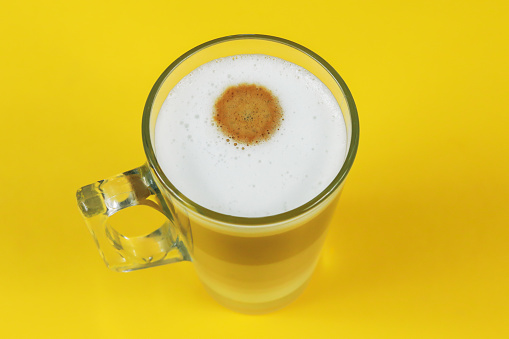 cup of cappuccino on a yellow background