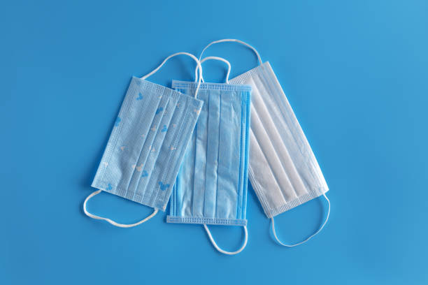 istock Three medical protective mask isolated on blue background 1218401570