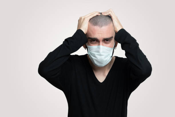 istock Young man sick with corona virus he has a headache his wearing face mask 1218401747