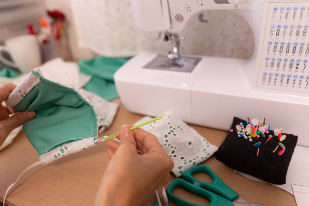 Close-up of hands holding a vibrant, handcrafted butterfly with yellow wings, purple markings, and a fluffy purple body. This image captures the joy and detail of a creative textile crafting project.