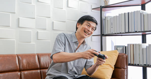 istock Senior Asian man using tablet and virtual reality simulator playing games in living room and feeling happy . Lifestyle Senior family at home concept. 1218402710