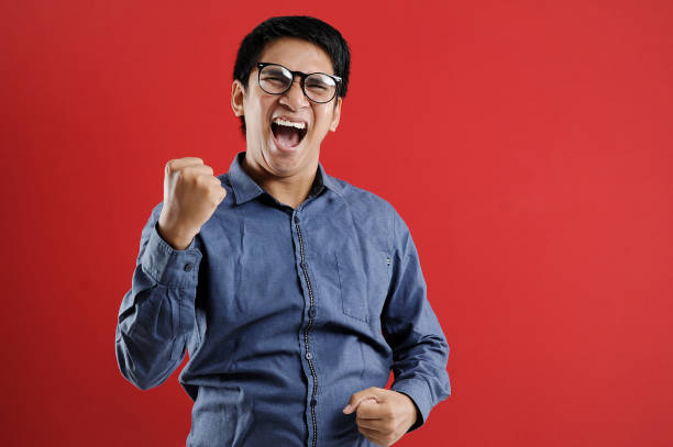 istock Young asian man happy and excited expressing winning gesture. Successful and celebrating 1218404455