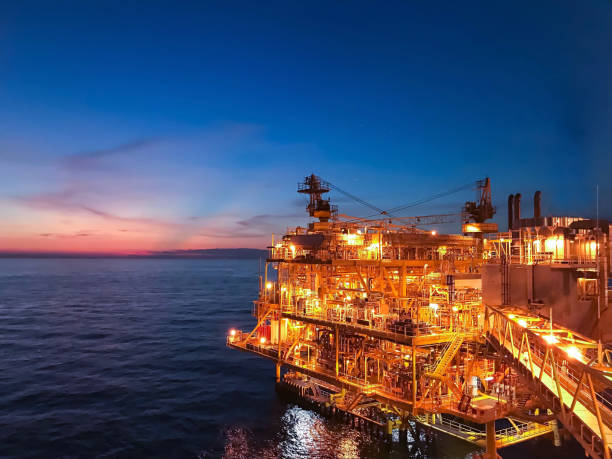 istock Offshore construction platform for exploration and production oil and gas with bridge in evening time for power energy of the world concept. 1218405986