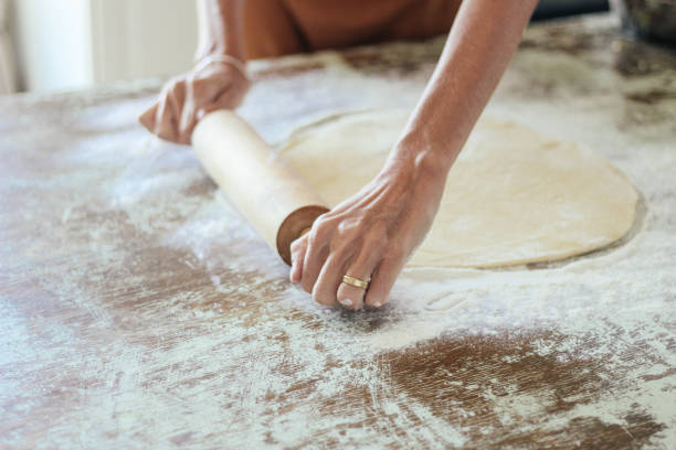 istock Close up of woman rolling dough with rolling pin 1218406098