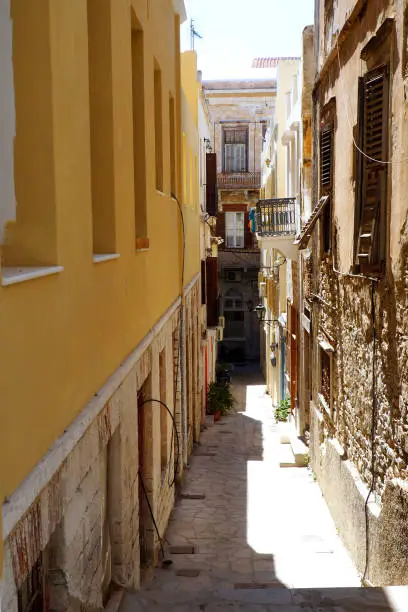 Photo of One of the charms of the Greek islands in the heart of the cyclades, are its narrow streets : white houses with small flowered balconies touching almost above paved streets