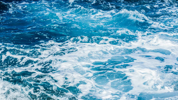 istock Waves crashing on rocks in blue ocean. 1218407353