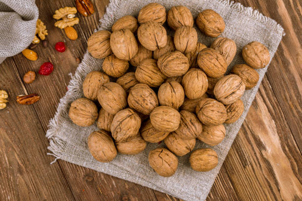 istock Closed walnuts on wooden background 1218407693