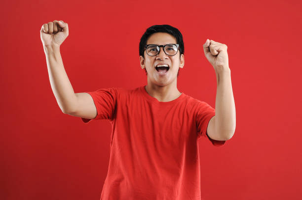istock Young asian man happy and excited expressing winning gesture. Successful and celebrating 1218409082