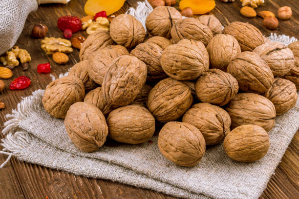 istock Closed walnuts on wooden background 1218409096