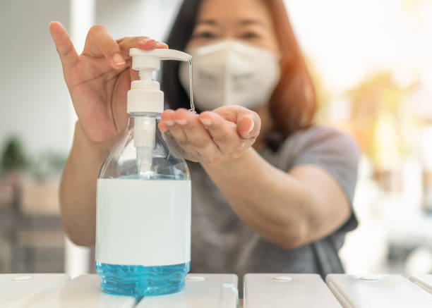 covid-19 outbreak, coronavirus pandemic prevention with woman wearing n95 face mask cleaning hand using alcohol gel sanitizer during quarantine for hygiene antibacteria safety - hand sanitizer liquid soap hygiene healthy lifestyle imagens e fotografias de stock