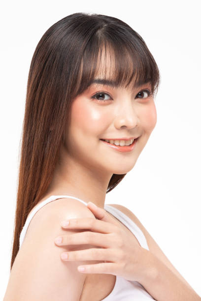 istock Beautiful Young Asian Woman Looking While Touching Shoulder feeling so happy and cheerful with healthy Clean and Fresh skin,isolated on white background,Beauty Cosmetology Concept 1218410588