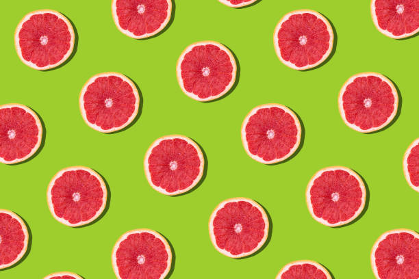 istock Flat lay fruit pattern of fresh grapefruit slices on green background. 1218411360