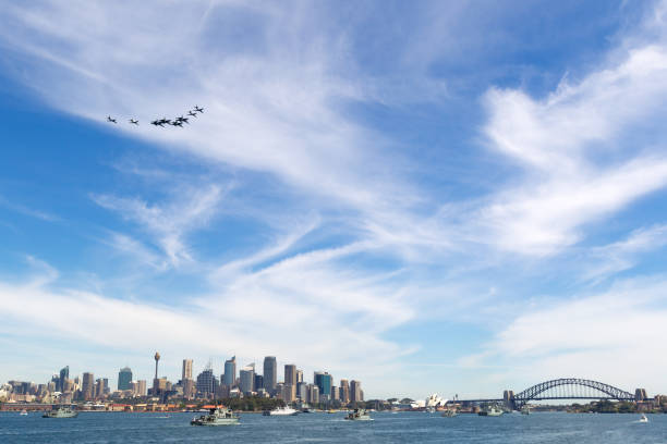 formation of eight royal australian air force (raaf) aircraft flying over sydney harbor with navy ships on the water. - military airplane mcdonnell douglas fa 18 hornet military fighter plane imagens e fotografias de stock