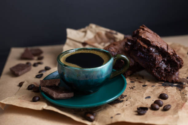 istock Coffee cup and brownies on craft paper on dark background 1218415323