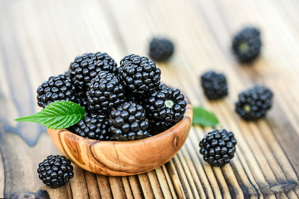 istock Blackberries in wooden bowl on rustic or old table. 1218416586