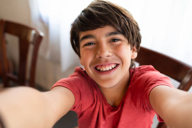 istock Cute latinx hispanic boy smiling while taking selfie at home 1218417775