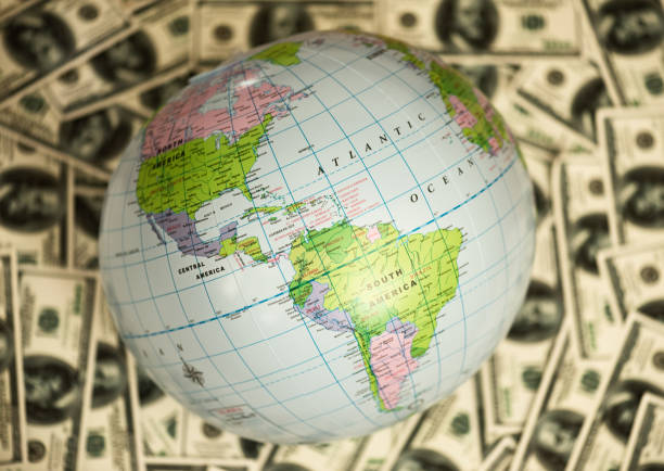 istock Globe lying on the background full of money 1218419269