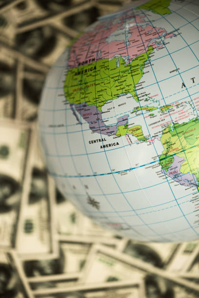 istock Globe lying on the background full of money 1218419284