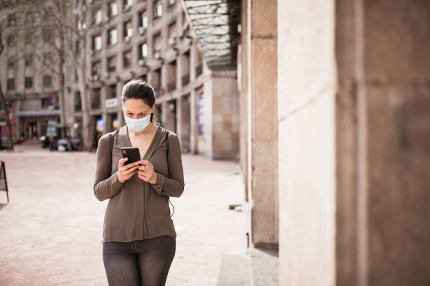 istock Woman wearing protective mask, texting 1218419432
