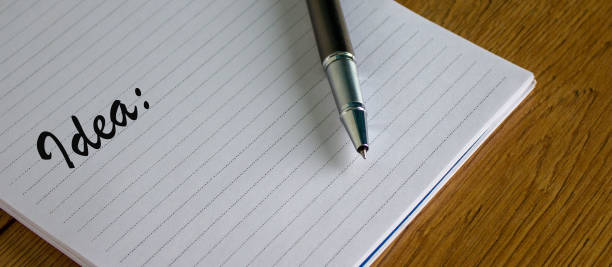 istock Notebook with the inscription idea and pen on wood table. 1218419539