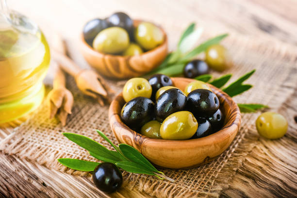 istock Fresh olives on old wooden rustic table or board. 1218421105