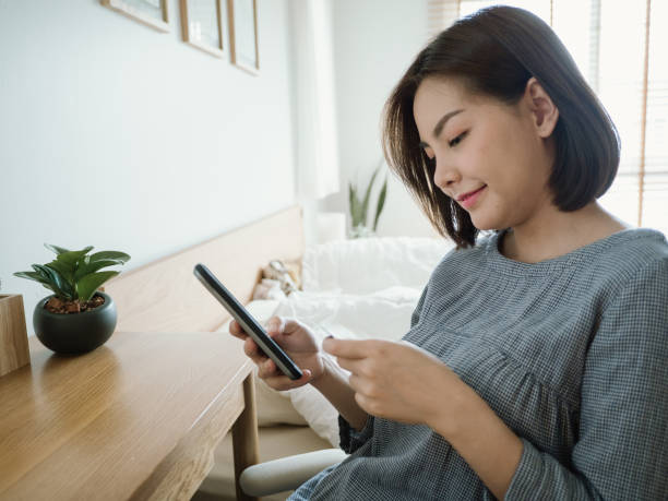 istock Young woman using a laptop with credit card while relaxing at home 1218422308