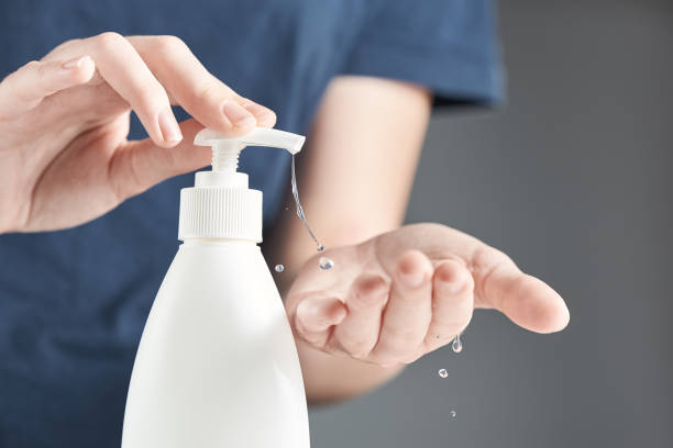 Female hands using hand sanitizer gel pump dispenser.