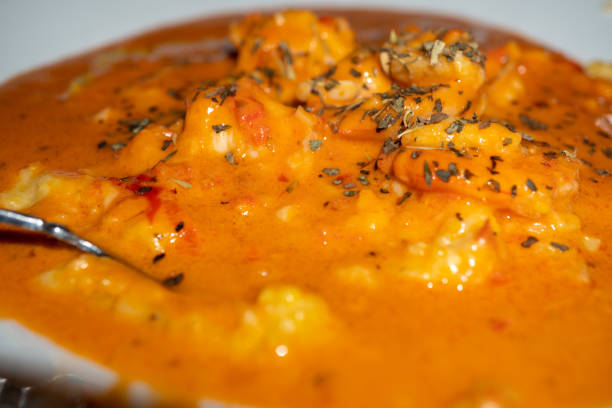 shrimp and grits with a tomato cream sauce topped with basil - grits prepared shrimp restaurant food imagens e fotografias de stock