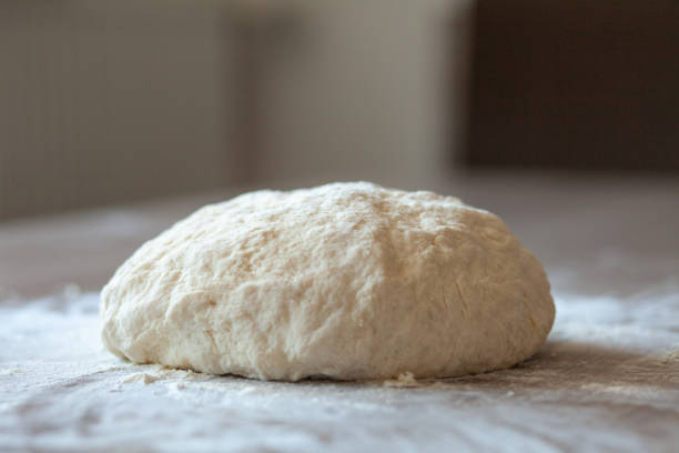 istock Fresh raw dough for pizza or bread on wooden table sprinkled with white flour 1218426503