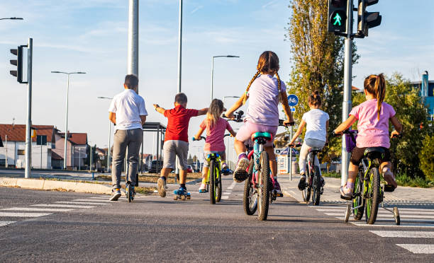 Little boy and his family riding bicycles in nature. The boy is smiling happily.\nNikon D810