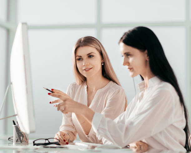 istock two employees are discussing something sitting at the office ta 1218428170