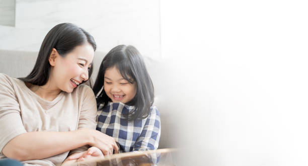 mãe e filha menina brincando sua mãe em sofá sala de estar em casa. conceito de família asiática feliz - kissing child family isolated - fotografias e filmes do acervo