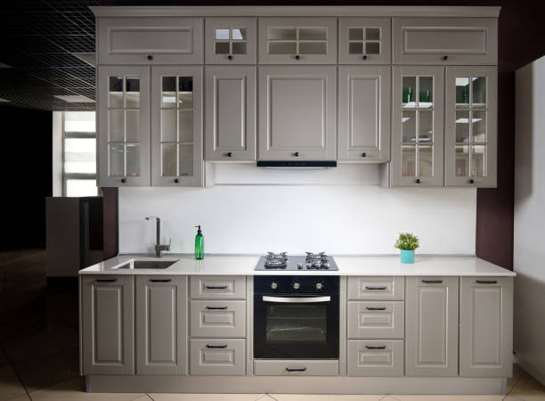 istock Interior of white and grey kitchen, horizontal, linear layout. Luxury modern fitted flat design kitchen with glass elements. 1218430492