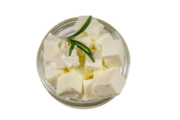 Feta cheese cubes with rosemary in glass bowl isolated on white background